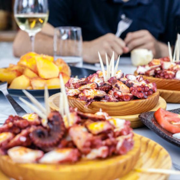 istockphoto-922562780-612×612 People eating Pulpo a la Gallega with potatoes. Galician octopus dishes. Famous dishes from Galicia, Spain.